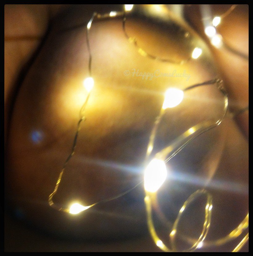 A naked plumptious (large) breast seen through a haze of lights from.fairy lights.